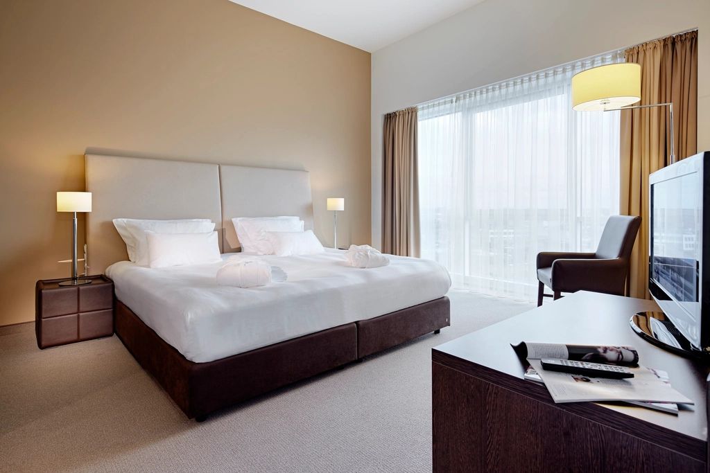 A guest room with a large bed and soft lighting